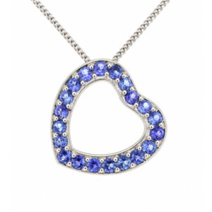 A heart shaped pendant with grain set round Tanzanite. designed to sit at an angle designer modern pendant gold platinum chain
