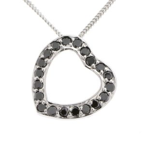 A heart shaped pendant with grain set round black diamonds. designed to sit at an angle designer modern pendant gold platinum