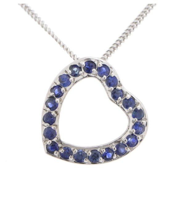 A heart shaped pendant with grain set round blue sapphires. designed to sit at an angle designer modern pendant gold platinum chainplatinum chain