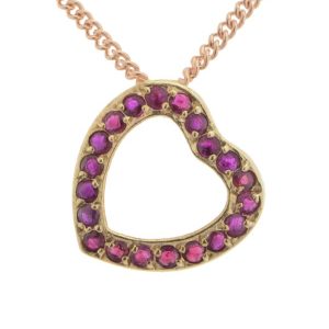 A heart shaped pendant with grain set round ruby rubies. designed to sit at an angle designer modern pendant gold platinum chain