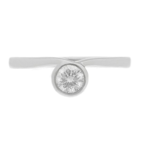 contemporary ribbon style crossover engagement ring set with a round brilliant cut solitaire diamond platinum gold