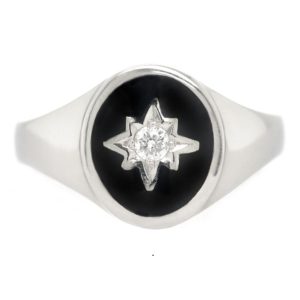 An Art deco style oval signet ring black enamel star set round brilliant cut diamond