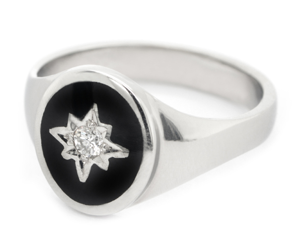 An Art deco style oval signet ring black enamel star set round brilliant cut diamond