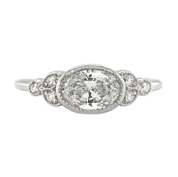 Classic art deco style ring oval shape cut diamond centre stone millgrain round diamonds shoulders setting engagement platinum gold