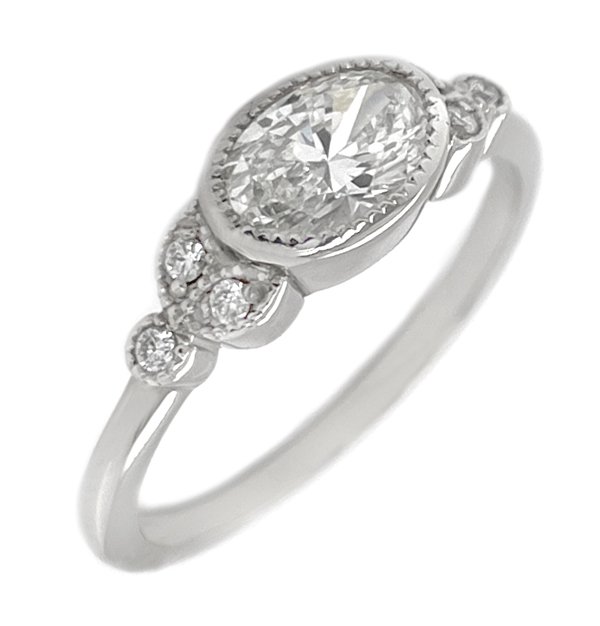 Classic art deco style ring oval shape cut diamond centre stone millgrain round diamonds shoulders setting engagement platinum gold