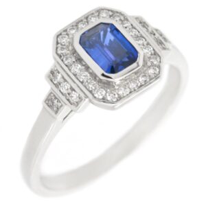 Classic 1920's art deco style emerald cut Blue Sapphire halo ring round brilliant cut diamonds surround stepped shoulders platinum gold