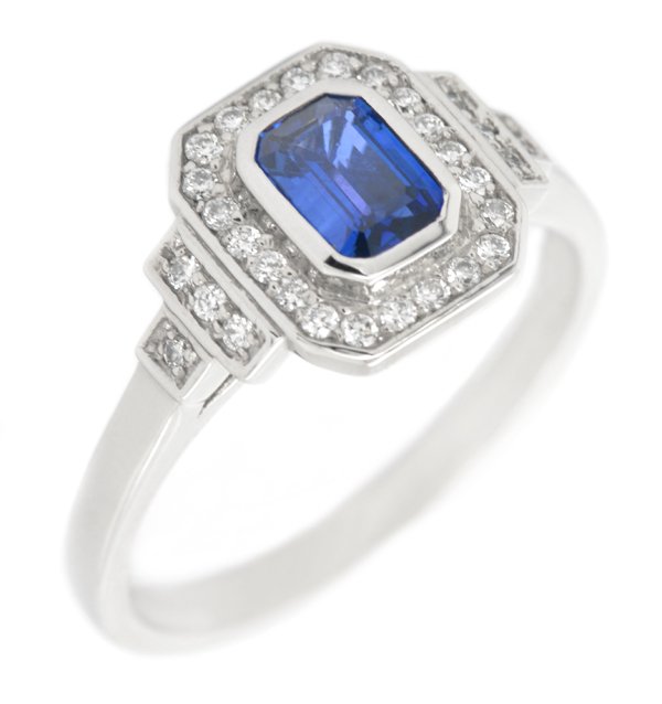 Classic 1920's art deco style emerald cut Blue Sapphire halo ring round brilliant cut diamonds surround stepped shoulders platinum gold