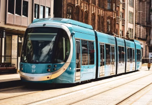 image of a blue tram moving through birmingham