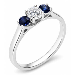 classic trilogy style ring round diamond centre stone & two blue sapphire side stones claw set setting gold platinum